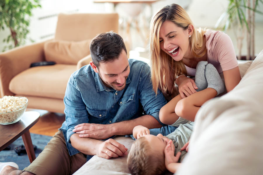 Personal Insurance - Happy Family on the Couch Playing with a Two Year Old